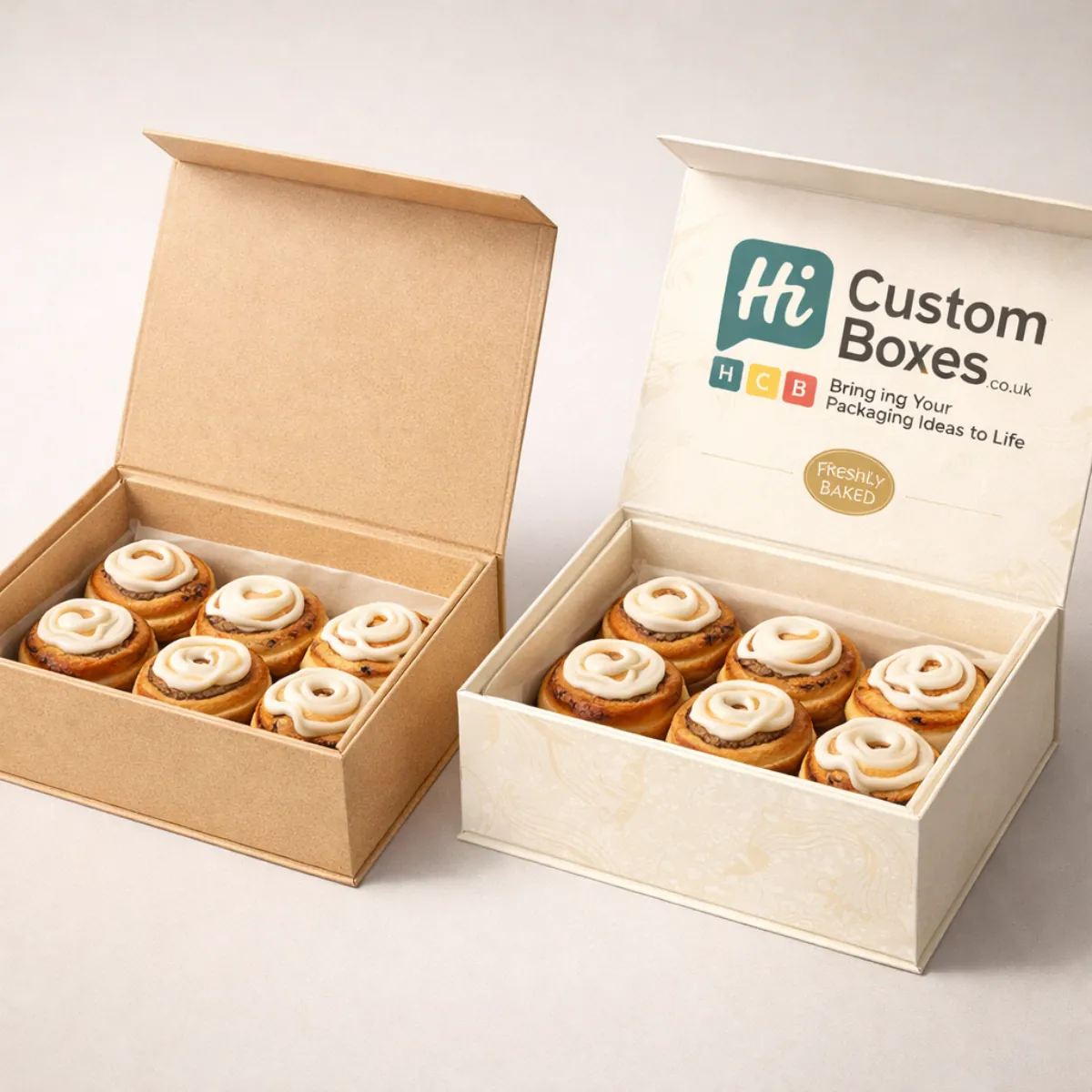 Two premium magnetic-lid boxes filled with six iced cinnamon rolls, one plain kraft and one patterned. class=